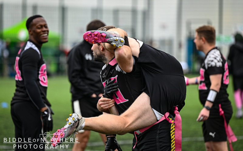 A flag american football player carrying another player on his back